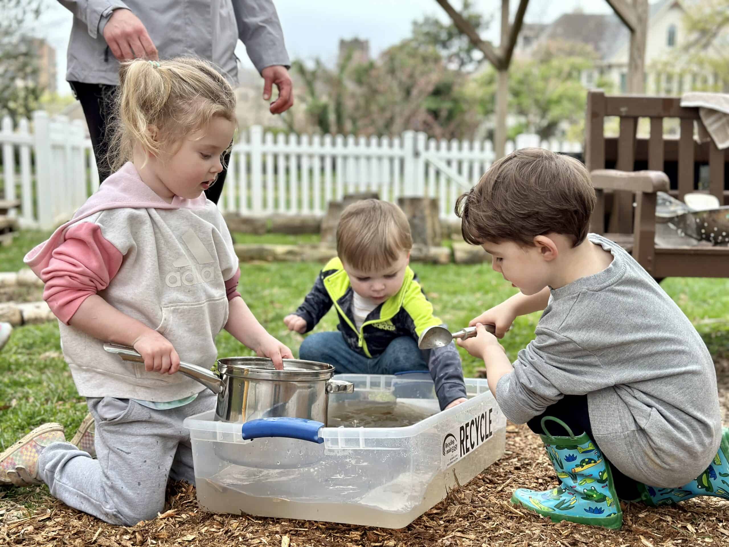 Children playing on playground equipment at Trinity Episcopal Preschool, showcasing a safe and engaging outdoor environment for early childhood development.