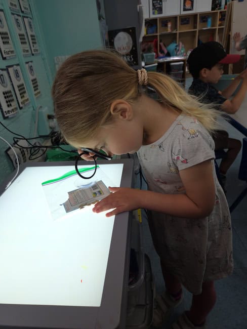Preschool girl engaging with an educational touchscreen table at Trinity Episcopal Preschool, focusing on early childhood education, technology in preschool, and interactive learning activities.