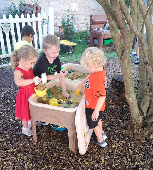 Children reading books inside a play tent at Trinity Episcopal Preschool.
